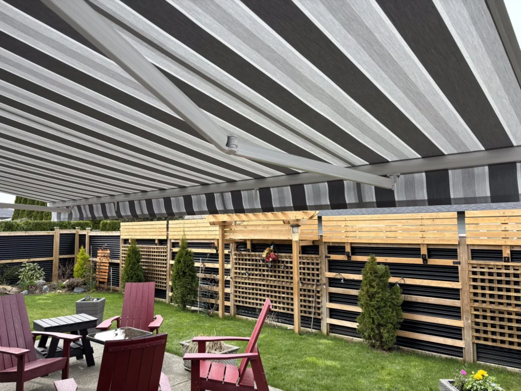 Retractable patio awning providing shade and rain protection for a backyard seating area on Vancouver Island